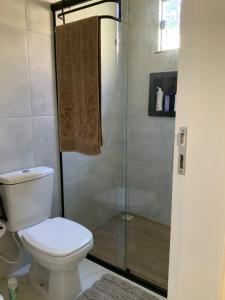 ein Badezimmer mit Toilette und Glasdusche in der Unterkunft Casa dos cajueiros in Paracuru