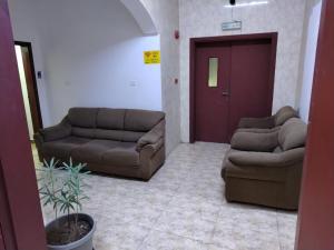 a living room with two couches and a door at international hoste in Muscat
