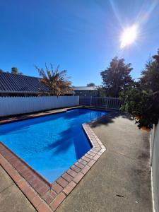a swimming pool in the backyard of a house at Cherry Grove Motel in Havelock North