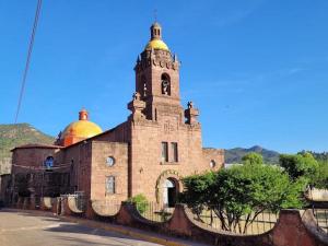 an old building with a tower with gold domes on it at Hotel Posada Doña Celes in Mesa Colorada