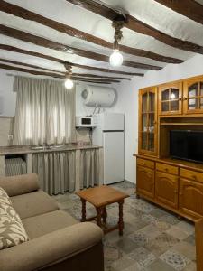 a living room with a couch and a tv and a table at Apartamento rural La Sabina in Zújar