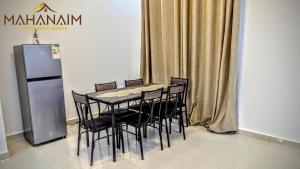 Una mesa de comedor con sillas y un refrigerador. en Mahanaim Luxury apartments, en Lusaka 2 fotos más