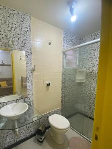 ein Badezimmer mit Waschbecken, Toilette und Dusche in der Unterkunft Apartamento central confortável in Pelotas