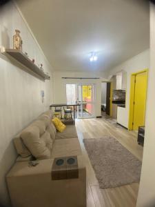 ein Wohnzimmer mit Sofa und Tisch in der Unterkunft Apartamento central confortável in Pelotas