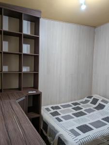 ein Schlafzimmer mit einem Bett und einem Bücherregal in der Unterkunft Apartamento central confortável in Pelotas