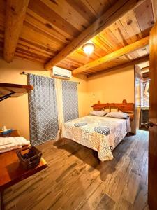 a bedroom with a bed in a room with wooden ceilings at Cabañas Villa Escondida in Urique