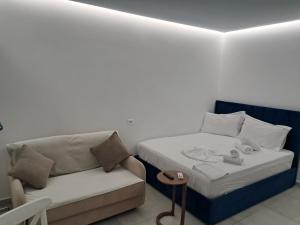 a bed and a couch in a room at Apartments Keesi 1 in Durrës