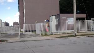 a white picket fence in front of a building at Departamentos Rohe in Puerto Montt