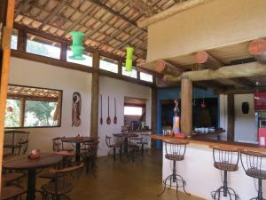 a bar with tables and chairs in a restaurant at Praia da Crioula in Vargem Bonita