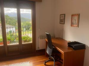 Una oficina con un escritorio y una silla y una ventana. en El Chalet Del Golf, en Urturi