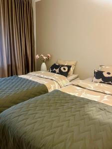 two beds sitting next to each other in a bedroom at UPEA keskustan kaksio in Kuopio