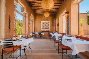 a dining room with white tables and chairs at Dar 55 - Berber House - Boutique Hôtel & SPA in Marrakesh
