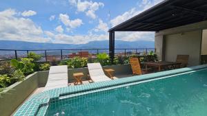 a swimming pool with chairs and a table on a roof at BRENT 30 Living in Medellín