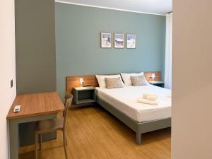 ein kleines Schlafzimmer mit einem Bett und einem Schreibtisch in der Unterkunft THE GEM - Short-Term Rental in Tirano