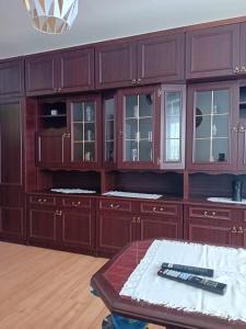 a kitchen with wooden cabinets and a table at Kawalerka in Gdańsk