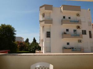 a white building with a white chair in front of it at Apartments In Amor in Ulcinj
