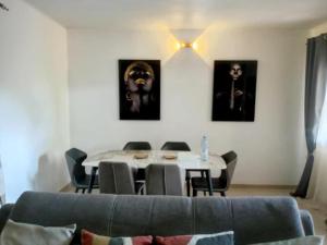 a living room with a couch and a table with chairs at Appart Ker L'AM in Lada