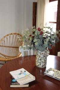 a vase with flowers and a book on a table at Gaia Rural Cazorla in Cazorla
