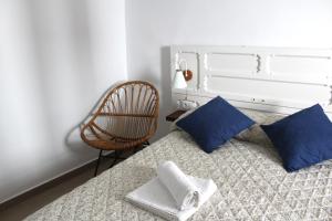 a bedroom with a bed with blue pillows and a chair at Gaia Rural Cazorla in Cazorla +12 photos