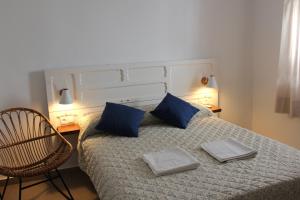 a bedroom with a bed with blue pillows and a chair at Gaia Rural Cazorla in Cazorla