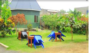 a group of tables and chairs in front of a house at ndugu gardens kasese guest house in Kasese