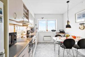 a kitchen with a table and chairs and a window at 5598-Allinge-Ndr-Strandvej-4-A-1-th in Allinge