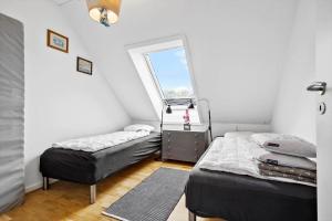 a bedroom with two beds and a window at 5598-Allinge-Ndr-Strandvej-4-A-1-th in Allinge