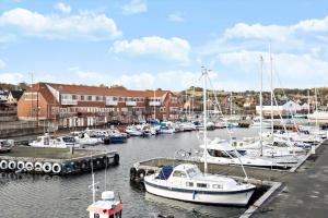 a group of boats docked in a marina with buildings at 5598-Allinge-Ndr-Strandvej-4-A-1-th in Allinge