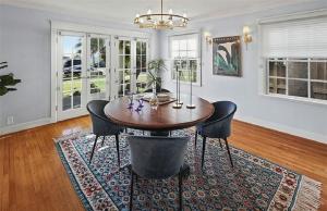 ロングビーチにあるHistoric Three-Bedroom Coastal Home with Expansive Ocean Viewsの木製のテーブルと椅子のあるダイニングルーム