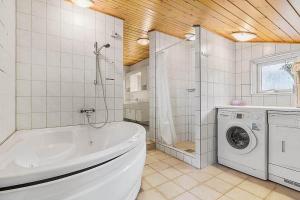 a bathroom with a tub and a washing machine at 2512-Nexo-Rokjinkan-7 in Vester Sømarken +23 photos