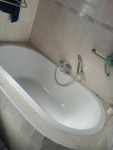 a white bath tub in a bathroom at Cosmel Guest House in Klerksdorp +16 photos