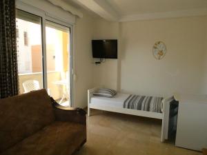 a living room with a bed and a tv on the wall at Apartments In Amor in Ulcinj