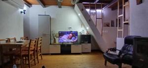 a living room with a tv and a table and a staircase at Vikendica Savic TKM in Pale