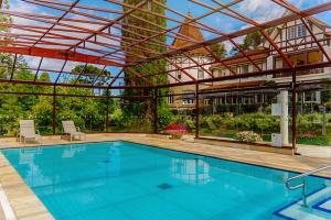 a large swimming pool with a pavilion with at Hotel Vila Inglesa in Campos do Jordão