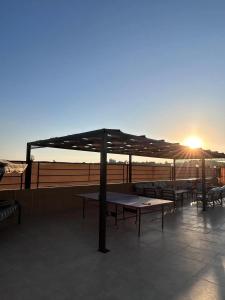 a patio with tables and chairs with the sun setting at Mountain farm in Ajloun +34 photos