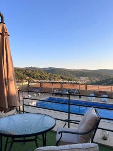 a patio with a table and chairs and a pool at Mountain farm in Ajloun