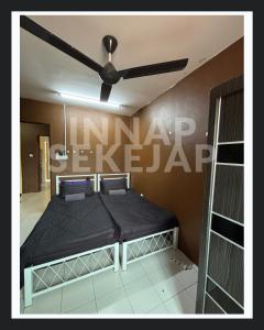 a bed in a room with a ceiling fan at Homestay Tapah INNAP SEKEJAP in Tapah +13 photos