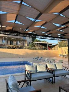 a pool with lounge chairs and a swimming pool at Mountain farm in Ajloun
