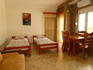 a room with two beds and a table and chairs at Apartments In Amor in Ulcinj
