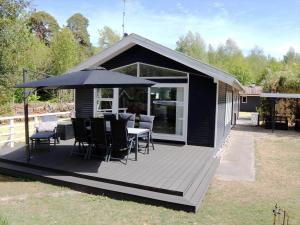 a deck with a table and an umbrella at 4759-Ronne-Stampen-Vej-1-Hus-4 in Rønne