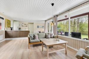 ein Wohnzimmer mit Sofa und Tisch in der Unterkunft 1512 Aakirkeby - Bjælkeåsen 3 in Vester Sømarken