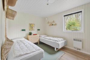 ein Schlafzimmer mit zwei Betten und einem Fenster in der Unterkunft 1512 Aakirkeby - Bjælkeåsen 3 in Vester Sømarken