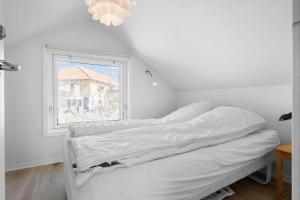 a white room with a bed and a window at 4728-Ronne-Brobakken-16 in Rønne