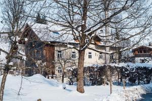 un gran edificio en la nieve con un árbol en Urlaub im alten E-Werk, en Görisried