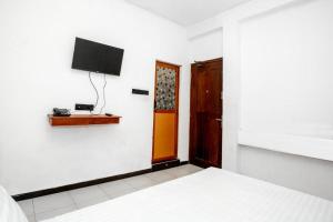 a bedroom with a bed and a television on a wall at Ez Stay Guesthouse in Colombo +22 photos