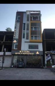 a building with a sign on the front of it at Tara Hotel & Restaurant in Kallar