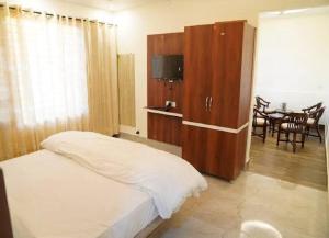 a bedroom with a bed and a cabinet with a television at Tara Hotel & Restaurant in Kallar