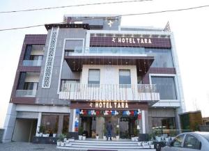 a building with a hotel with a sign on it at Tara Hotel & Restaurant in Kallar