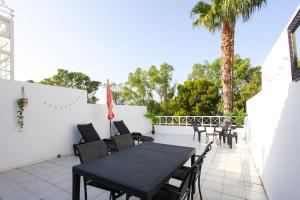 a patio with a black table and chairs and a palm tree at Wake up by the sea in your cozy Denia corner in Denia