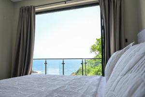 Un dormitorio con una cama con vista al mar. en Villa Jasiri, en Gros Islet